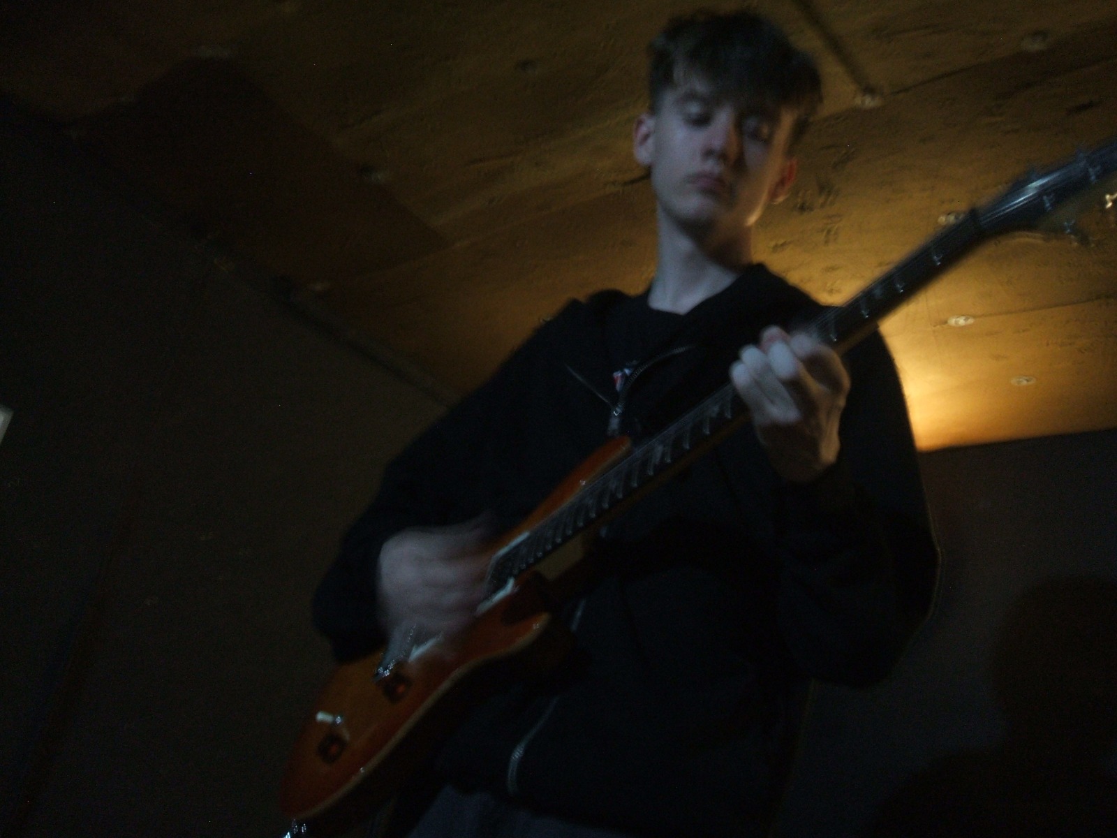 Musician playing guitar in a rehearsal space